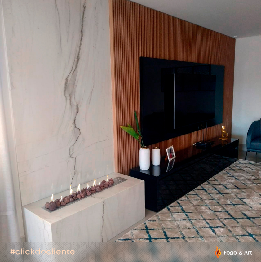 Imagem real de cliente mostrando tv na lareira instalada lateralmente, com distância segura entre o fogo e o aparelho eletrônico.